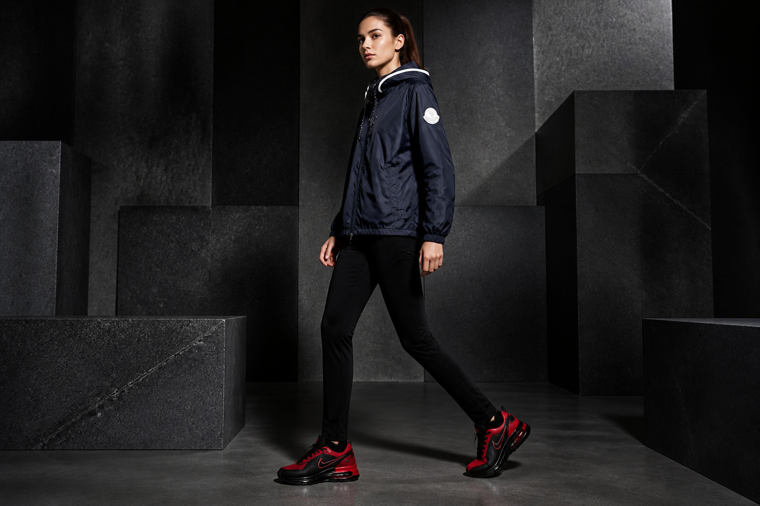 Model wearing a black and red Nike sneaker with a premium navy down jacket